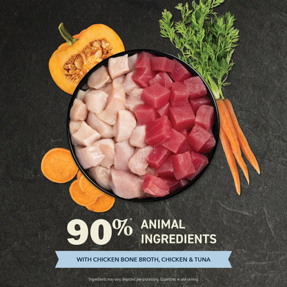 Pet food bowl with chicken, tuna, and vegetables on a dark background